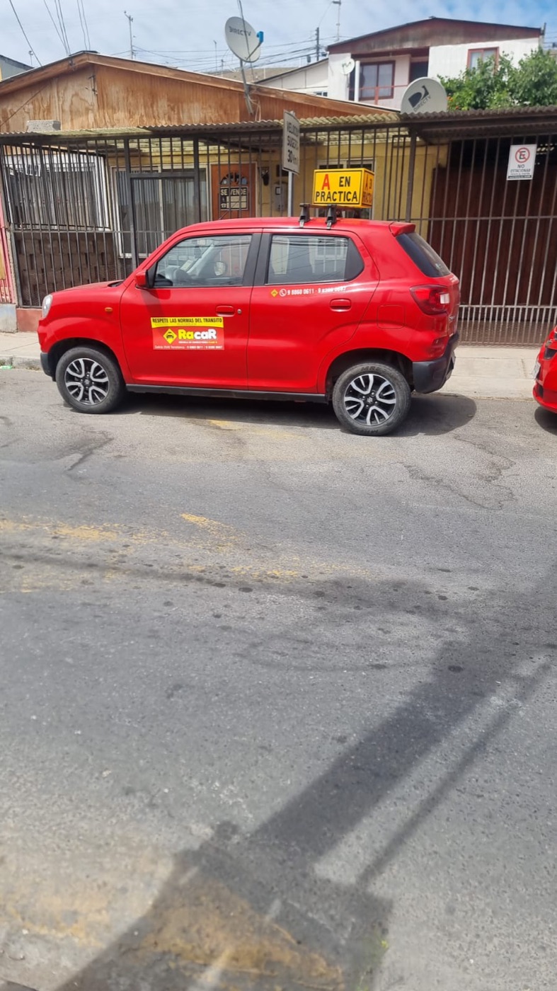 Auto rojo de la escuela con el cartel A en práctica estacionado en una calle de Vallenar