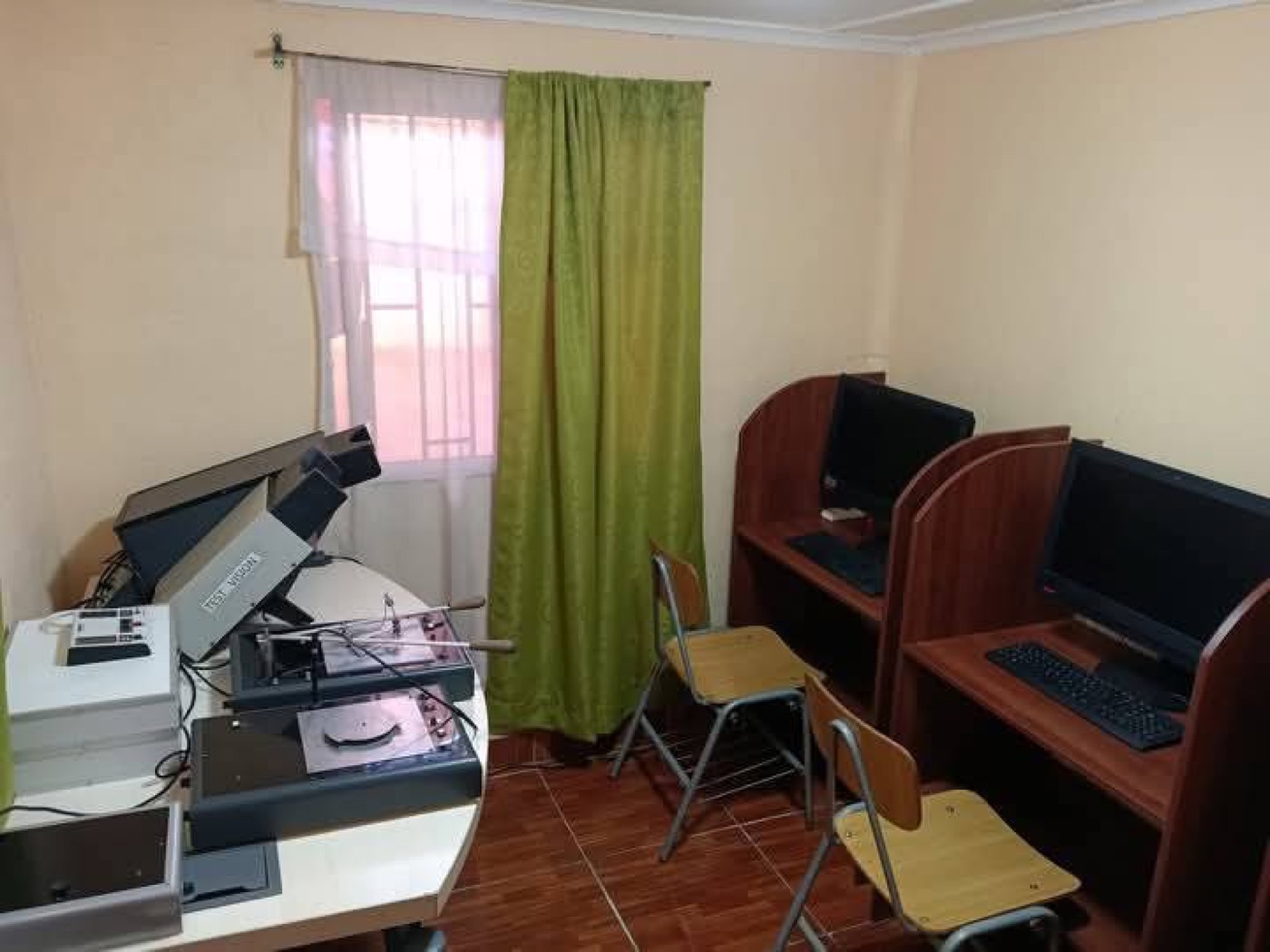 Sala con equipos de evaluación y computadores en cubículos de madera