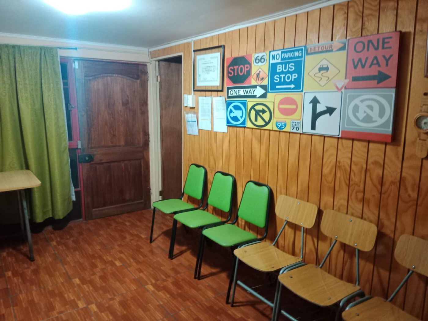 Recepción de la escuela con sillas verdes y un cuadro de señales de tránsito